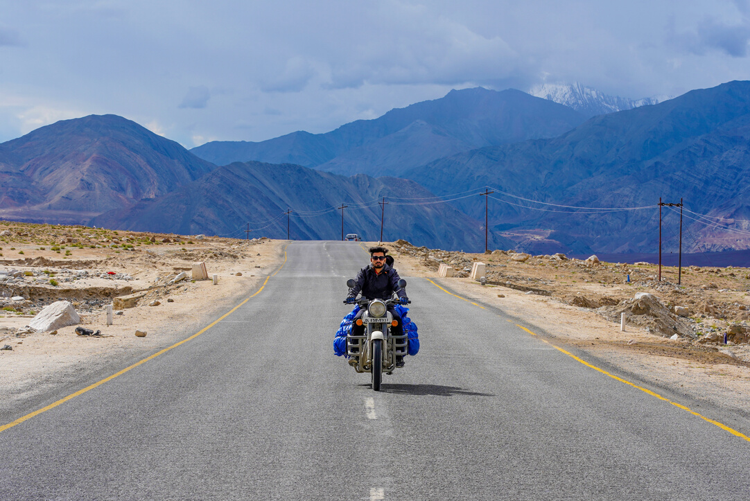 Man Riding a Motorcycle Passing by a Concrete Road